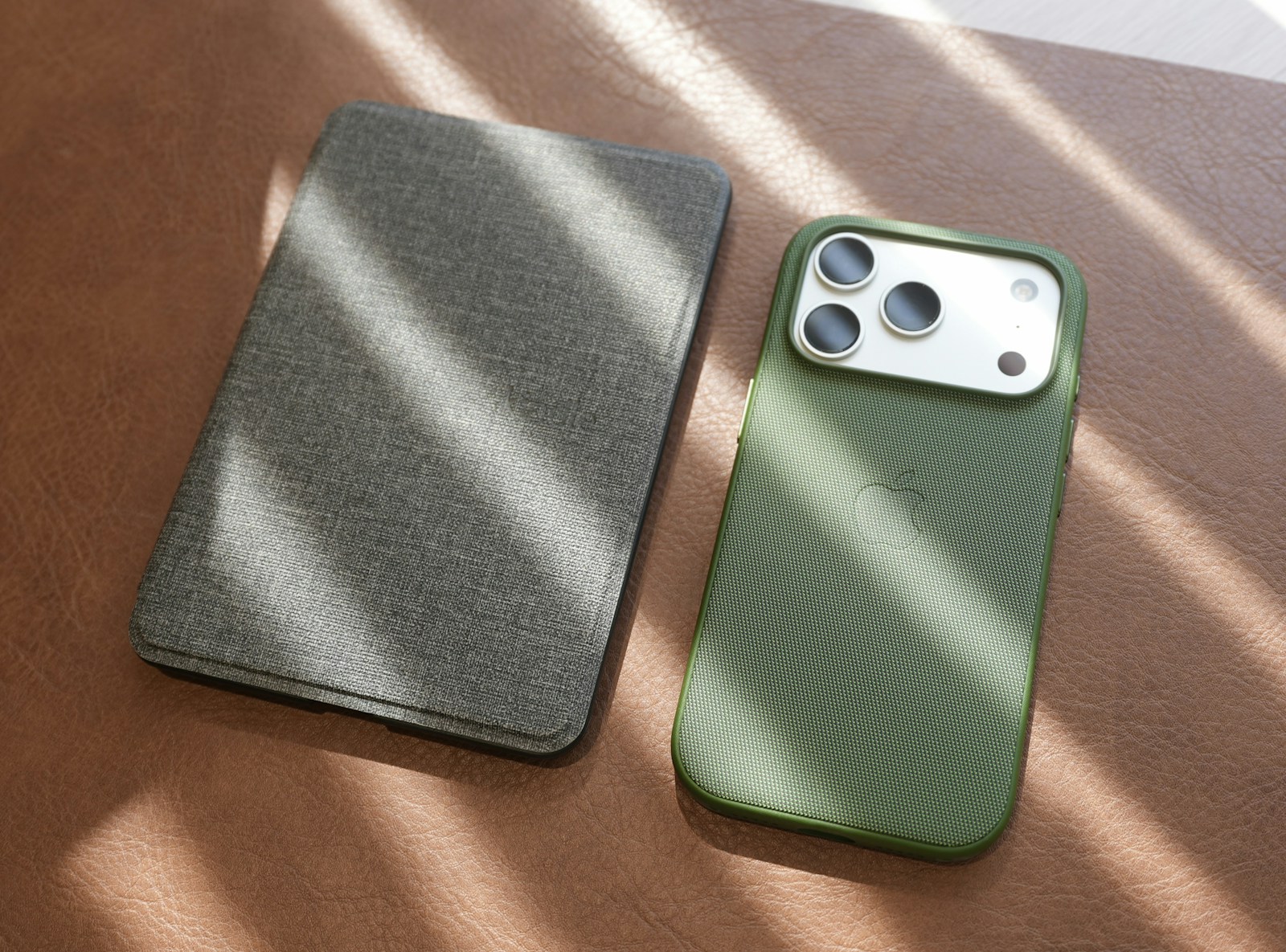Smartphone and covered tablet on a warm leather surface
