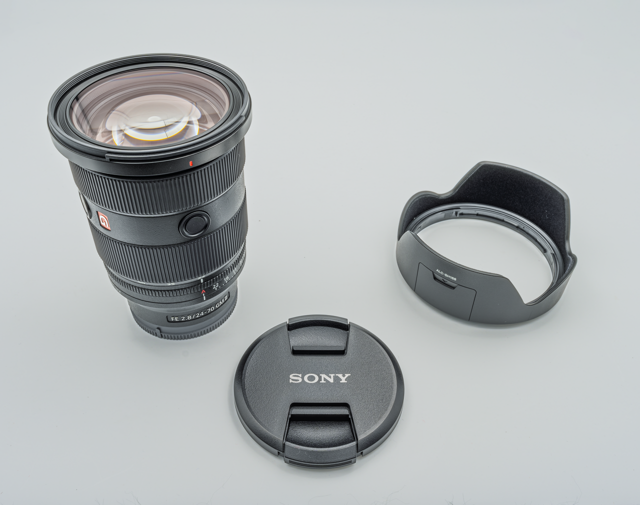 Sony FE 24-70mm F2.8 GM II lens, hood and cap on a light background